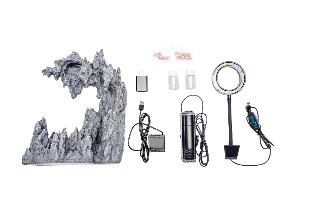 Everything included in the Aqua Worx C1 kit laid out: resin hardscape, sand, internal filter, waterfall pump and clip-on LED light