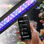 FluvalSmart app on a phone controlling the Marine 3.0 Bluetooth LED over a reef aquarium
